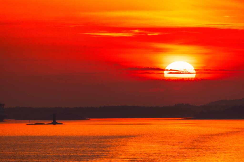 A breathtaking sunset over a calm sea with vibrant red and orange hues in the sky